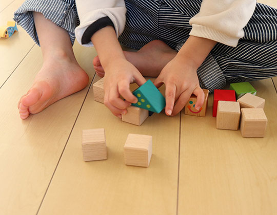 積み木を積み上げて遊ぶ子ども